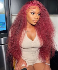 a woman with red curly hair sitting in a kitchen