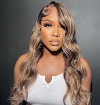 a woman with long wavy hair is posing for a photo