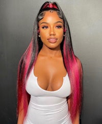 a black woman in a white top with pink and black hair