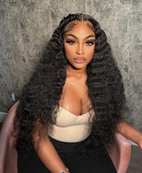 a black woman sitting on a chair with curly hair